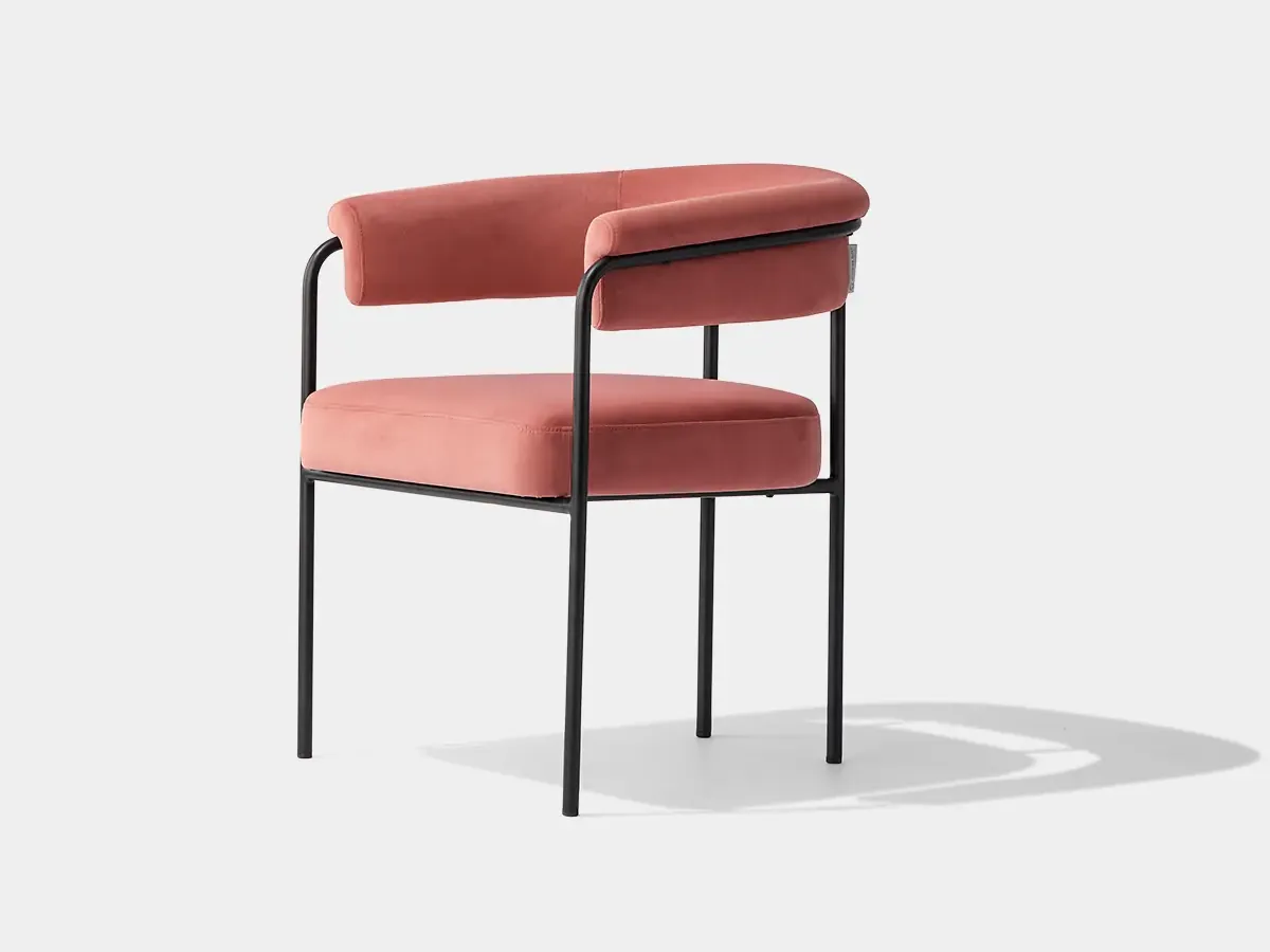 DC-F42 upholstered dining armchair, three-quarter view showing wraparound back and metal frame
